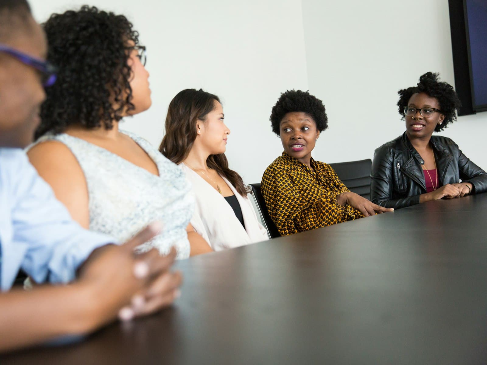 Four partners talk together around a conference table.