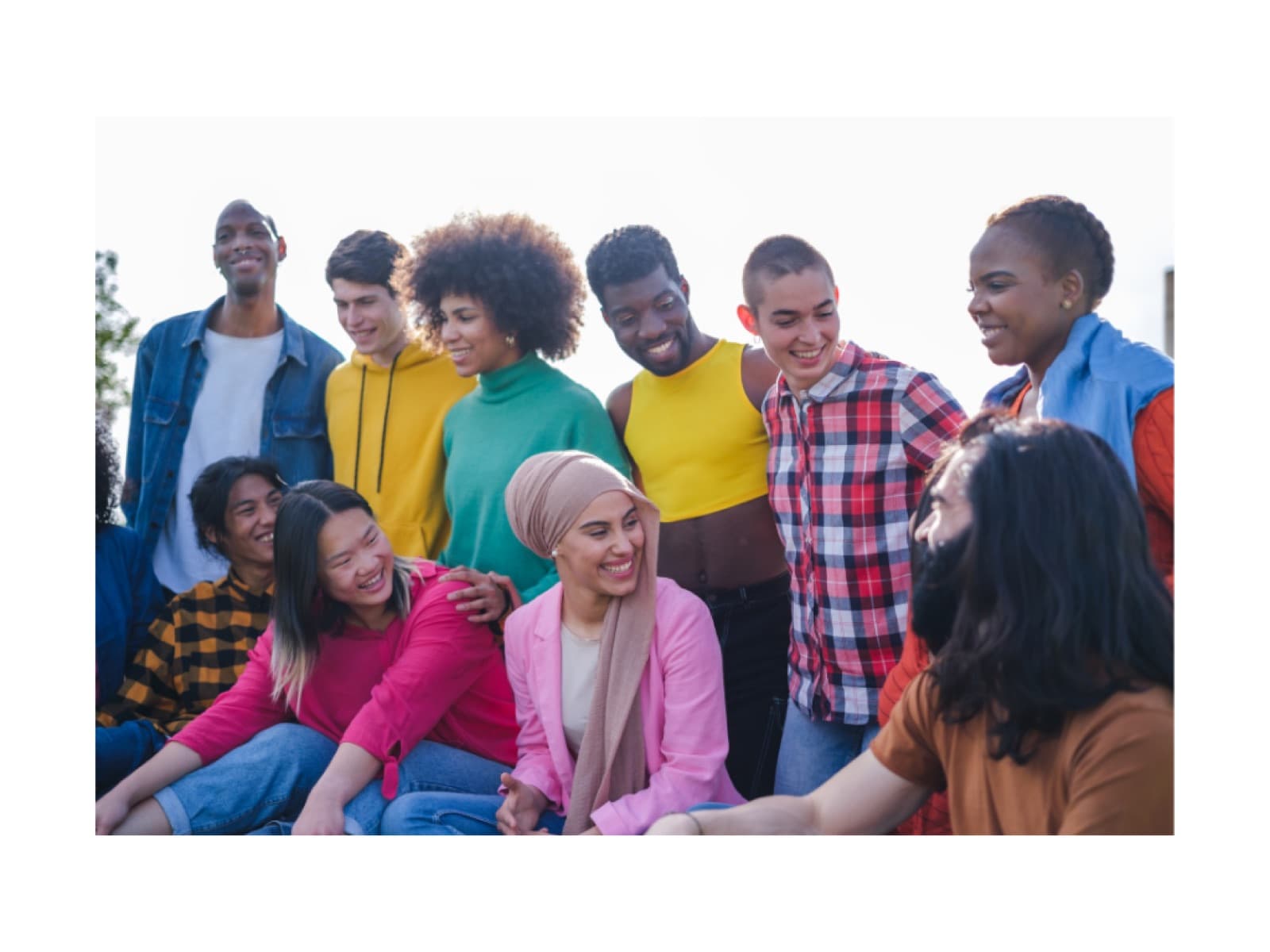 A diverse group of young people gather together, smiling.
